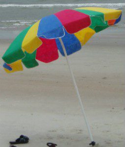 Colorful beach umbrella on sandy shore.