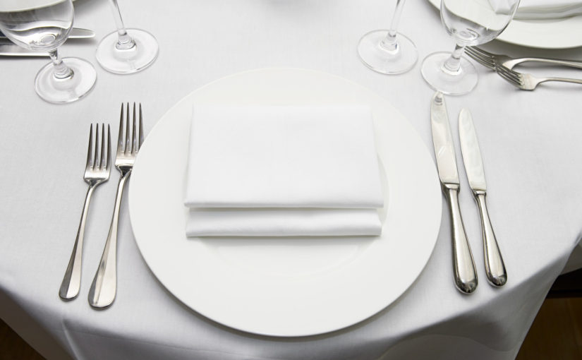 Forks, Knives, Plates, and Glasses Arranged on a Table