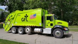 A GFL truck in green color parked at a space